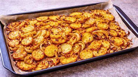 Cama de patatas y cebolla en una bandeja para horno