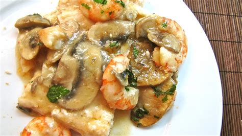 Merluza con gambas y setas en un plato
