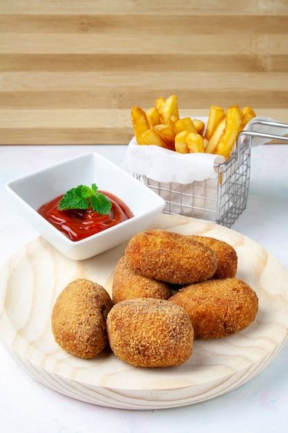 Croquetas doradas y crujientes sobre un plato de madera