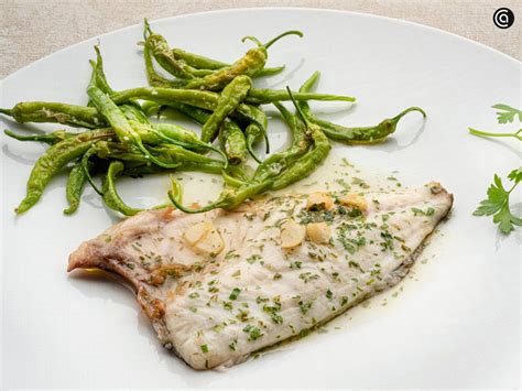 Detalle del refrito de ajos y guindilla sobre el pescado abierto