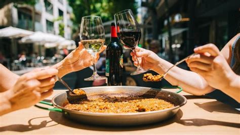 mesa puesta con paella tradicional y vino para degustación