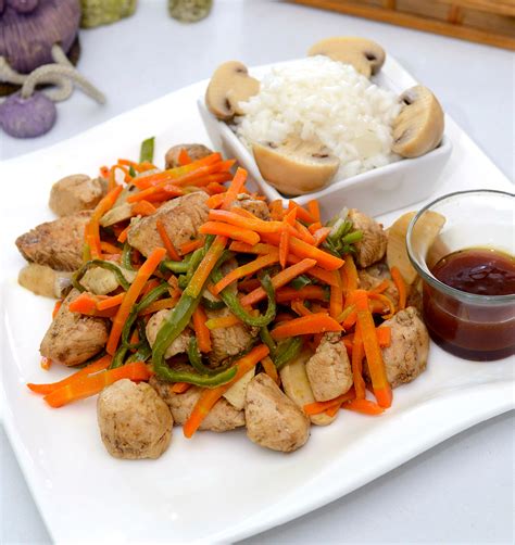 Pollo agridulce con verduras sobre un bol de arroz