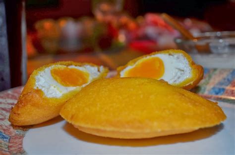Proceso de rellenar una arepa con huevo crudo
