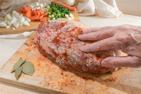 Mano espolvoreando especias sobre un trozo de carne