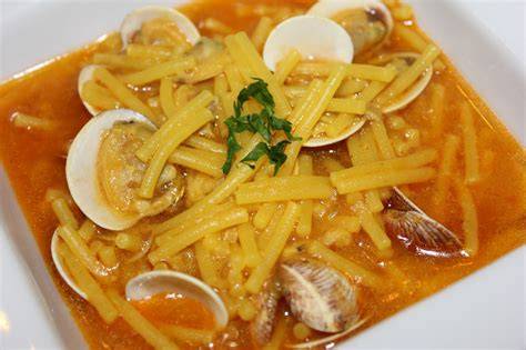Fideos cocinándose con almejas