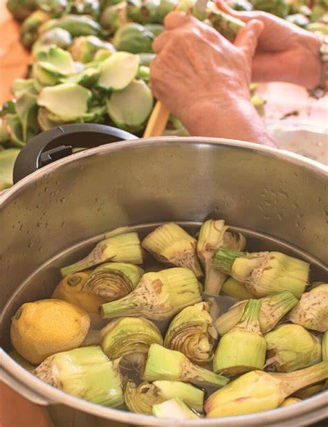 Proceso de limpieza y torneado de alcachofas frescas