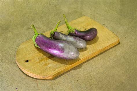 Zanahorias frescas y berenjenas sobre una tabla de madera