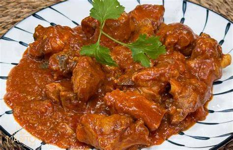 Plato de cordero al chilindrón tradicional servido en cazuela de barro