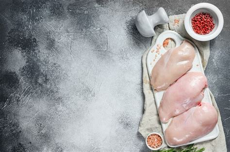 Pechugas de pollo crudas en una tabla de cortar