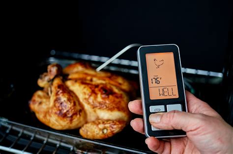 Termómetro de cocina insertado en una pechuga de pollo cocida