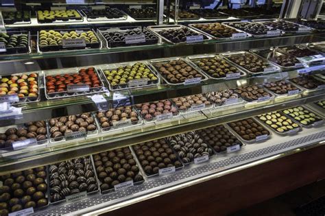 Selección de pasteles artesanales y bombones en una vitrina de Gijón