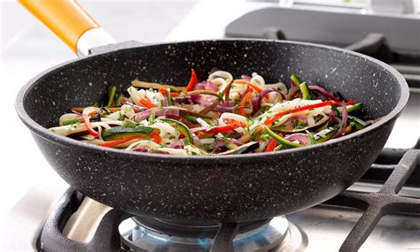 Persona utilizando un wok para saltear verduras