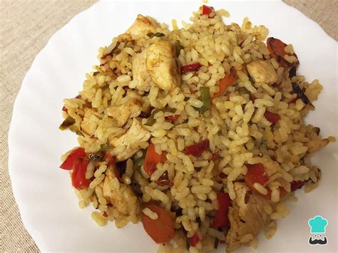 Plato de pollo salteado con champiñones y verduras sobre una base de arroz