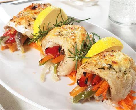 filetes de merluza rellenos de cangrejo servidos en plato elegante
