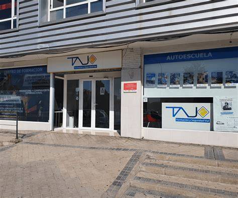 Fachada o instalaciones modernas de una autoescuela con señalización vial