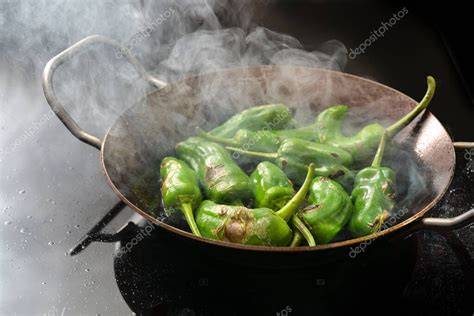 Pimientos verdes dorándose en una sartén antiadherente