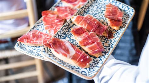 Plato de jamón de bellota con salmorejo y regañá en un entorno gourmet