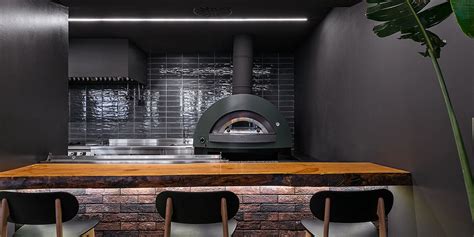 Interior de una pizzería moderna con horno de leña