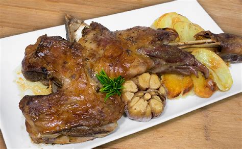 Plato de cordero asado con patatas y ensalada