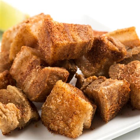 Chicharrones friéndose en un caldero con protector de salpicaduras