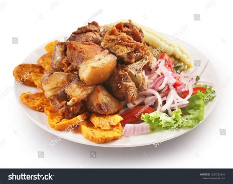 Plato de chicharrones de cerdo servidos con limón y tostones