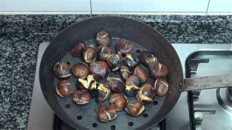 Castañas asándose en una sartén con agujeros
