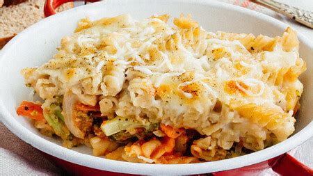 Plato de pasta gratinada con verduras con queso fundido