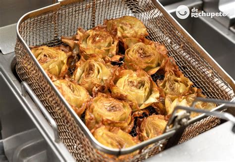 Alcachofas abiertas en forma de flor sobre una bandeja de horno