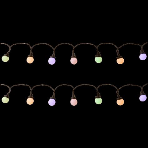 Guirnalda de luces de colores pastel en un jardín nocturno