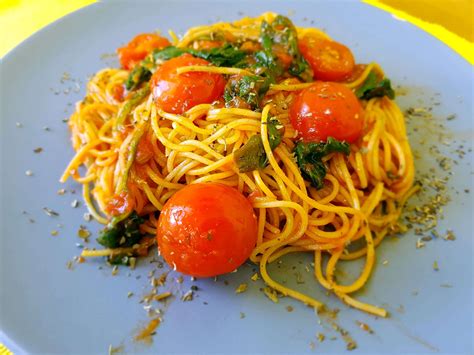 Plato de espaguetis con espinacas frescas y tomates cherry