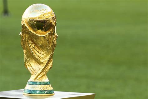 Fanáticos del fútbol posando con el trofeo de la Copa Mundial