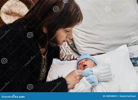 Abuela emocionada sosteniendo a su nieto recién nacido
