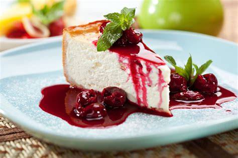 Tarta de queso curado servida con frutos rojos y un poco de mermelada
