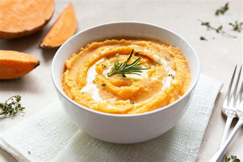 Plato terminado de puré de boniato decorado con pipas de calabaza, nueces y ralladura de naranja