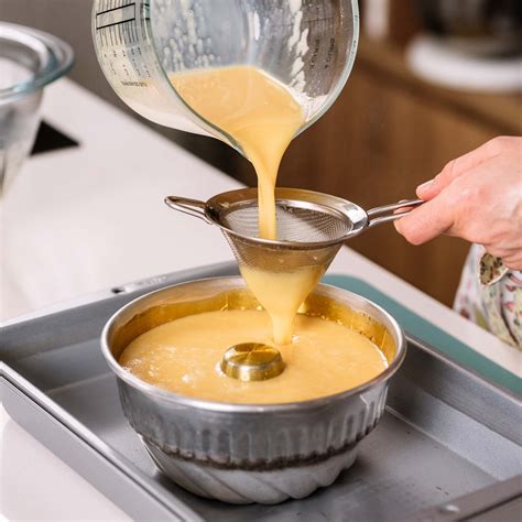 molde con flan dentro de una bandeja con agua para baño maría en el horno