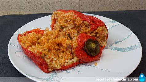 Pimientos rojos rellenos de arroz y carne asándose en el horno