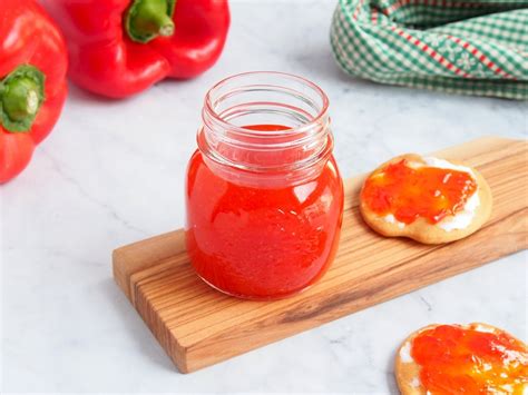 Tarro de mermelada de pimiento casera con pimientos frescos al lado