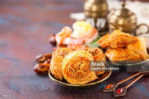 Variedad de postres árabes, incluyendo baklava, ma'amoul y kunafa