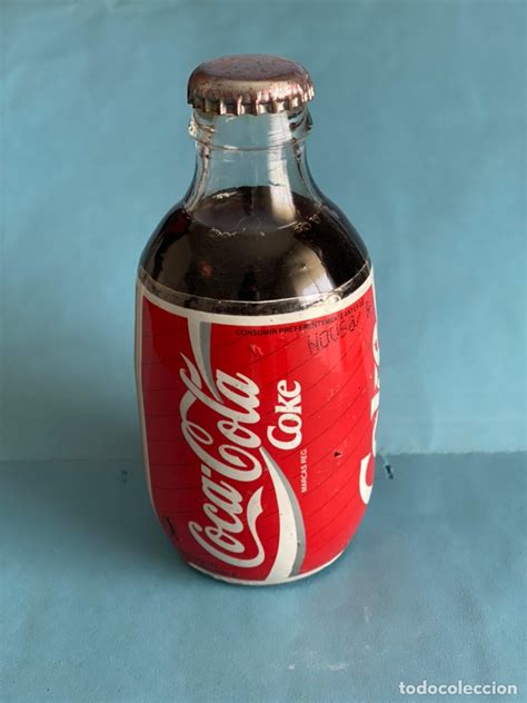 Botella antigua de Coca-Cola y hoja de coca y nuez de cola