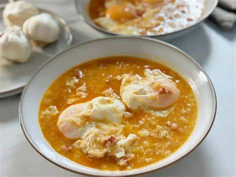 Plato de sopa de ajo tiernos servida