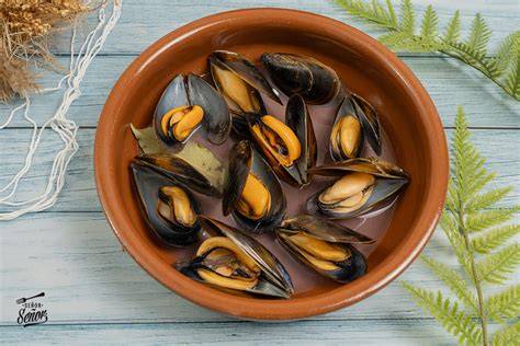 Mejillones y almejas abriéndose al vapor en una olla