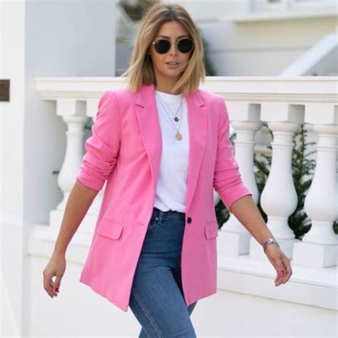 Mujer vistiendo un blazer rosa pastel con una blusa estampada