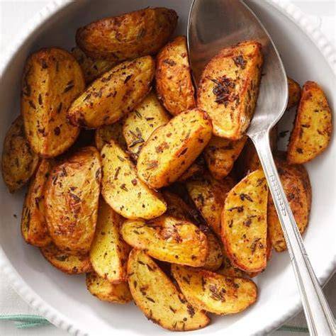 Patatas cortadas y sazonadas en la cesta de la freidora de aire