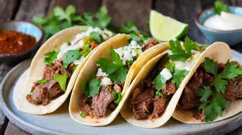 Tacos de barbacoa de res con acompañamientos