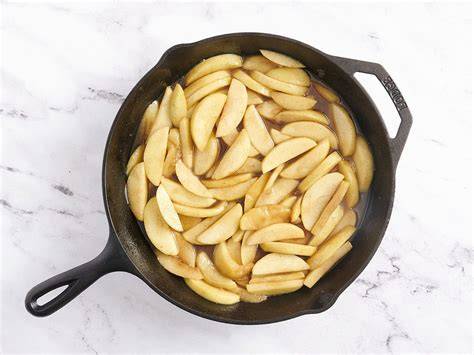 Manzanas cortadas y salteándose en la sartén