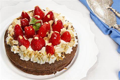 Tarta húmeda de chocolate sin gluten decorada con fresas y nata