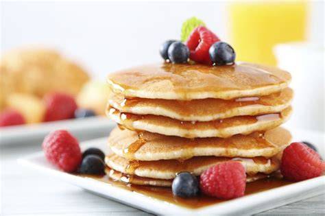 Pilas de tortitas americanas con sirope y frutas
