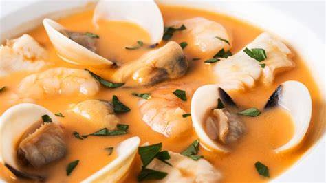 Sopa de merluza y almejas servida en un plato hondo