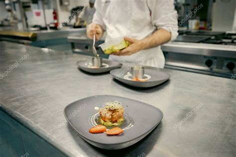 Un chef preparando una hamburguesa gourmet con ingredientes frescos