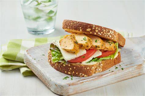 Proceso de montaje de un sándwich de pollo con zanahoria